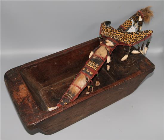 A tribal dagger and wooden trough